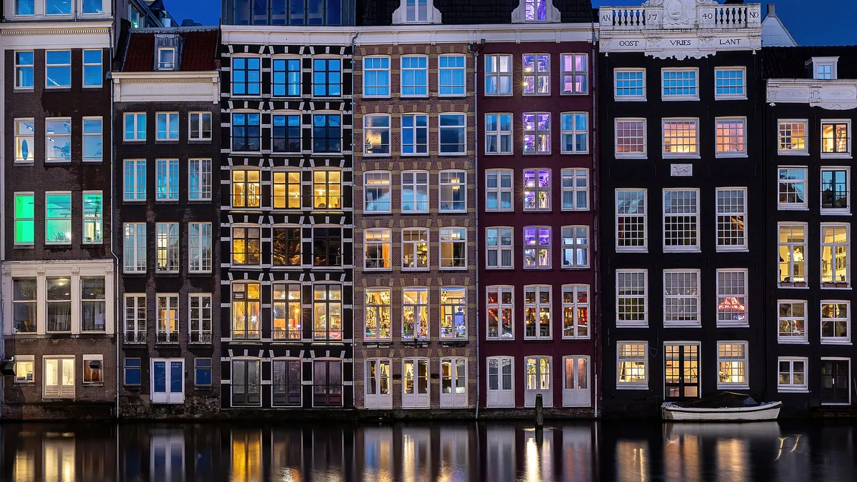 Les maisons colorées au bord de l'eau à Amsterdam, à l'heure bleue