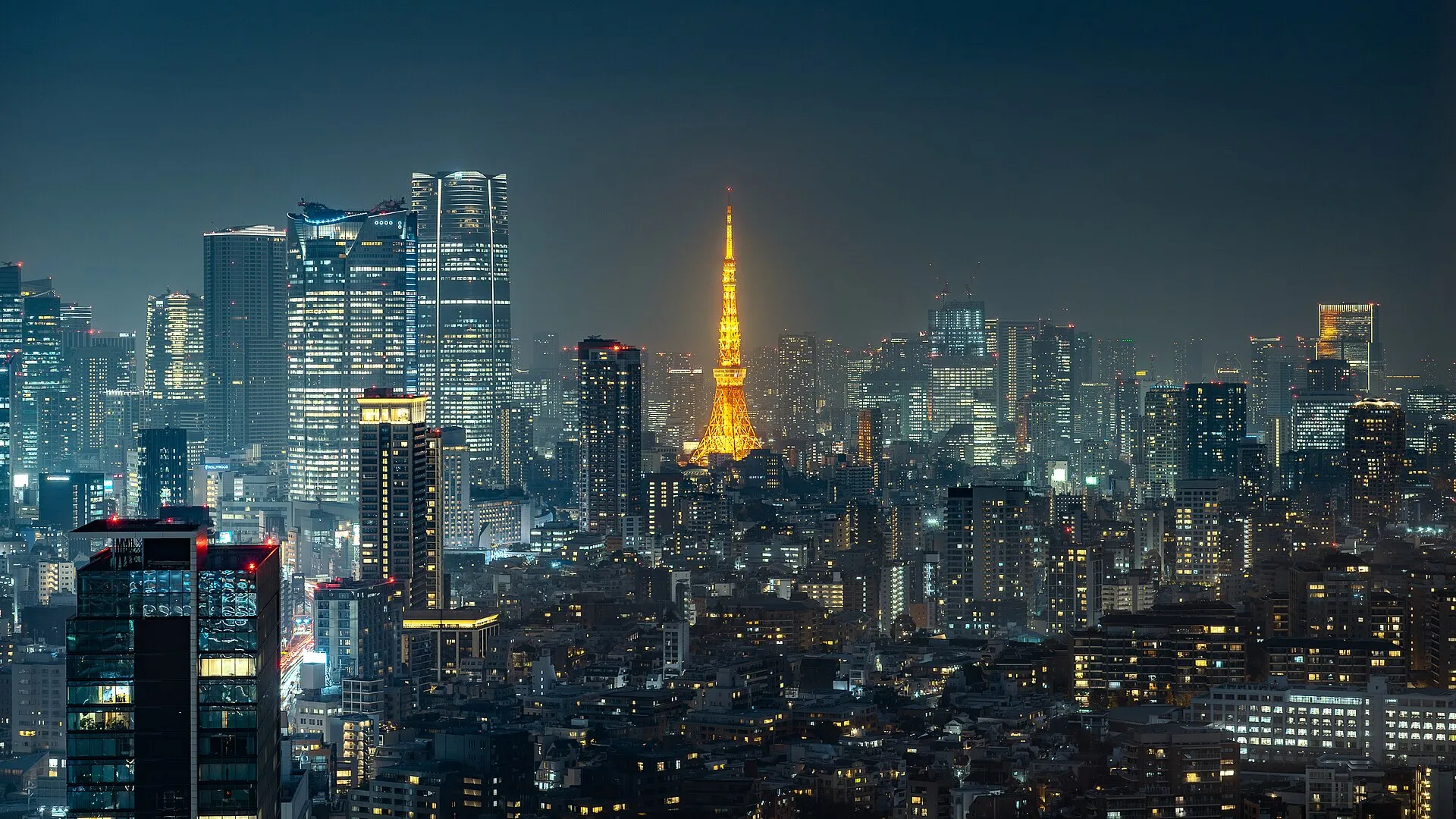 La tour de Tokyo illuminée au milieu des gratte-ciel, la nuit