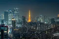 La tour de Tokyo illuminée au milieu des gratte-ciel, la nuit